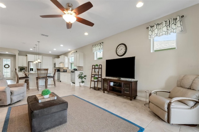 tiled living room with ceiling fan