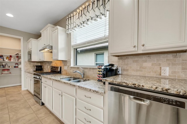 kitchen featuring white cabinets, sink, decorative backsplash, light stone countertops, and stainless steel appliances