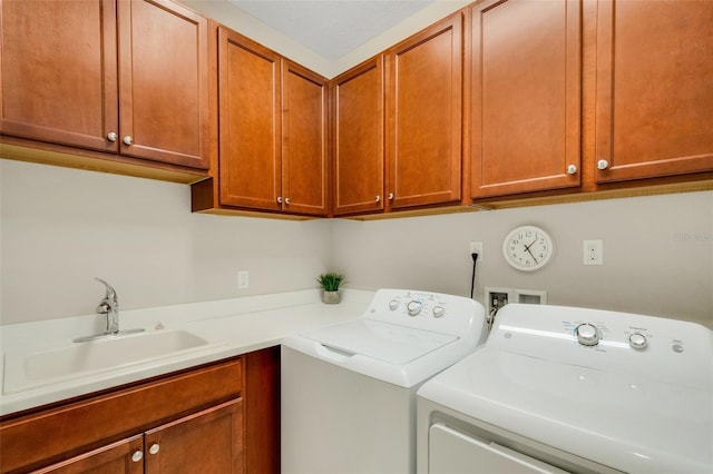 laundry area featuring separate washer and dryer, sink, and cabinets