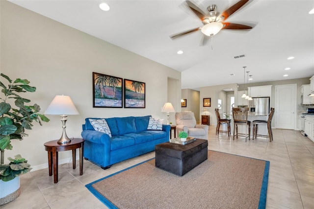 tiled living room featuring ceiling fan and lofted ceiling