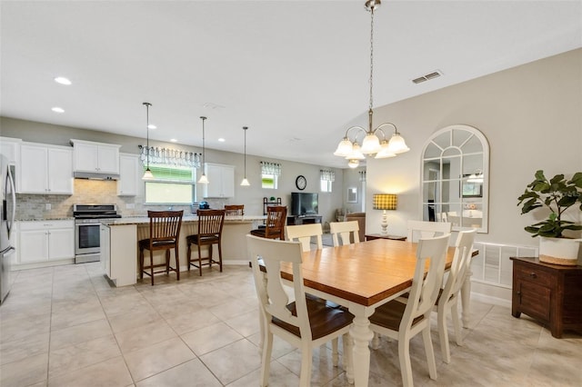 tiled dining room with an inviting chandelier