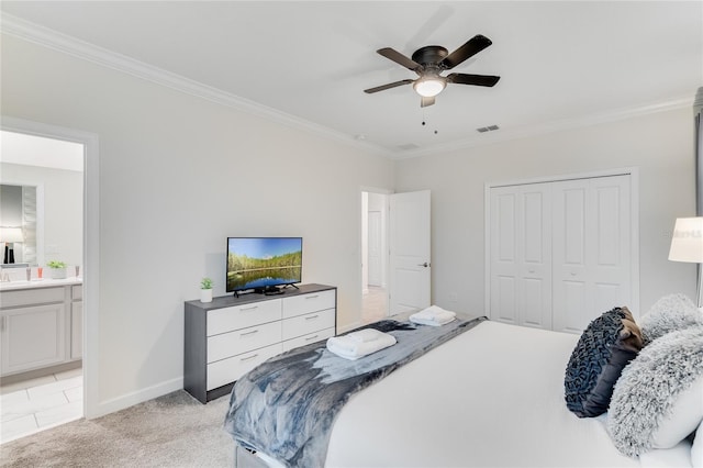 bedroom with crown molding, ceiling fan, connected bathroom, light carpet, and a closet