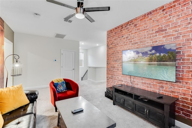 carpeted living room featuring ceiling fan and brick wall