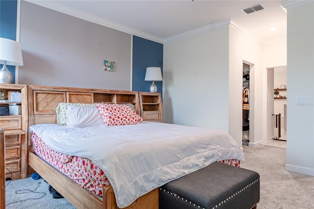 bedroom featuring crown molding, a walk in closet, and light carpet