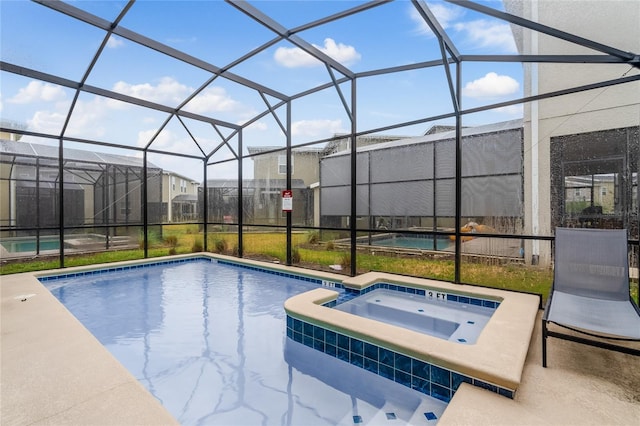 view of pool featuring an in ground hot tub, glass enclosure, and a patio