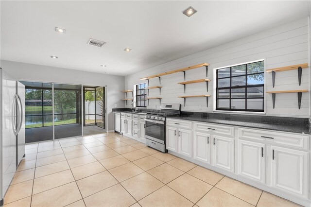 kitchen with white cabinetry, appliances with stainless steel finishes, sink, and light tile patterned floors