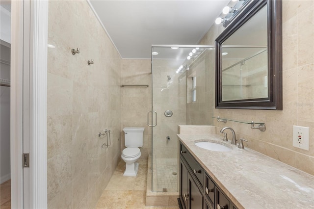 bathroom with walk in shower, toilet, tile walls, vanity, and tile patterned flooring