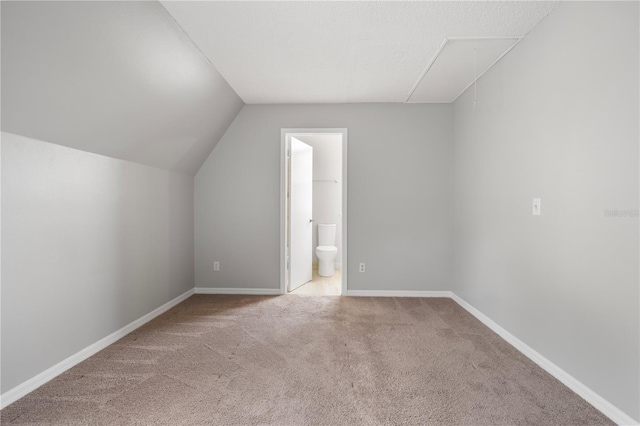 bonus room featuring lofted ceiling and light colored carpet