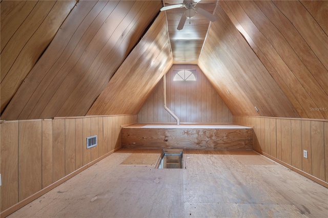 bonus room with vaulted ceiling, ceiling fan, and wood walls