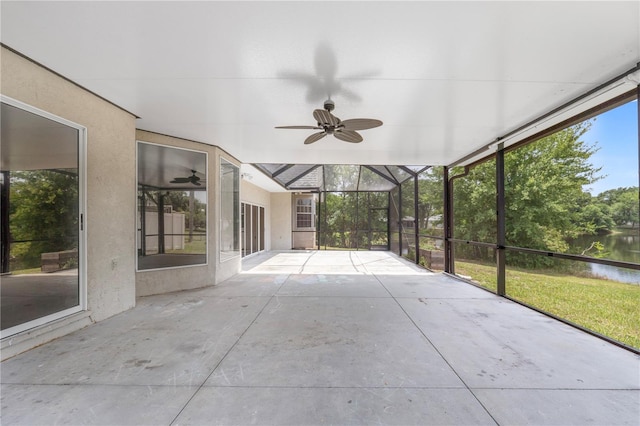 unfurnished sunroom with a water view and ceiling fan