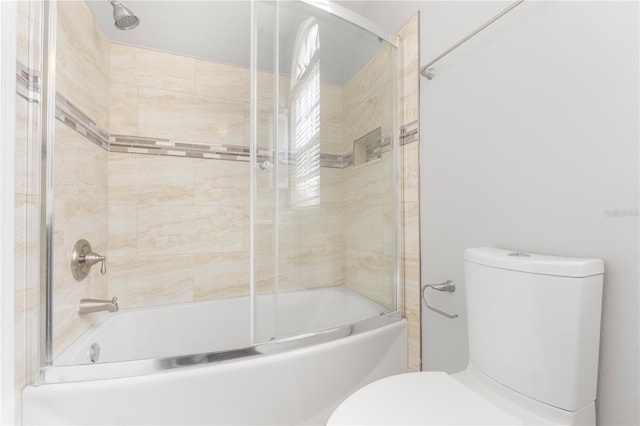 bathroom featuring enclosed tub / shower combo and toilet