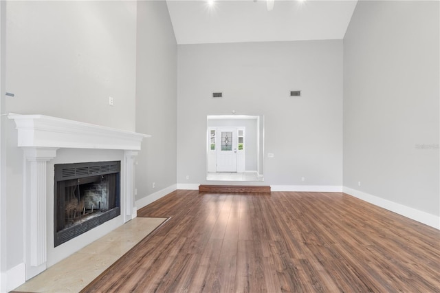 unfurnished living room with hardwood / wood-style floors and a high ceiling