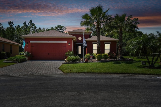 view of front of property with a garage and a lawn