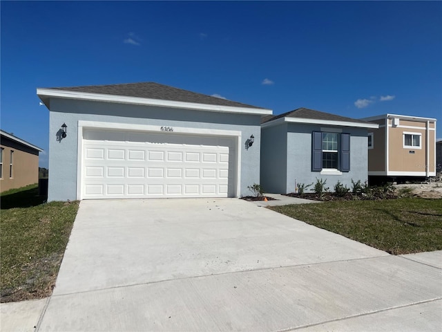 ranch-style house featuring a front yard and a garage