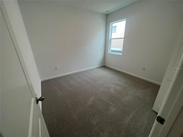 empty room featuring dark carpet