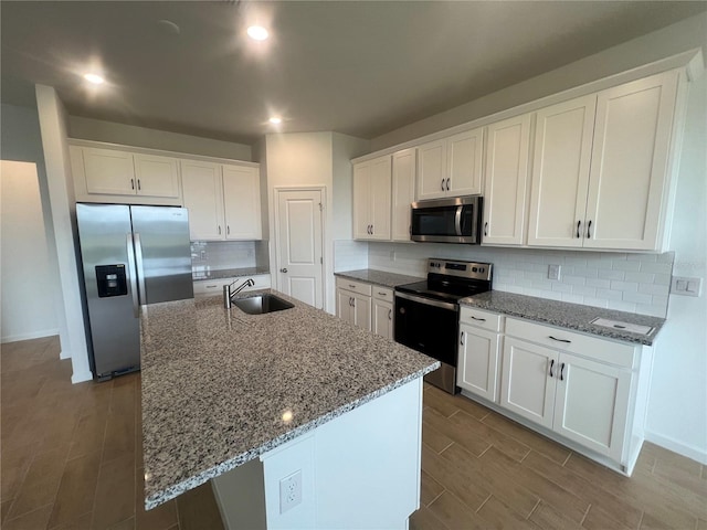 kitchen featuring a center island with sink, stainless steel appliances, white cabinets, and sink