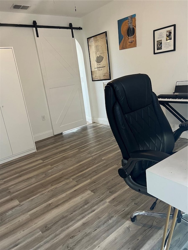 office with hardwood / wood-style floors and a barn door