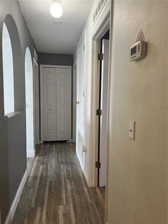 corridor featuring dark hardwood / wood-style floors and a textured ceiling