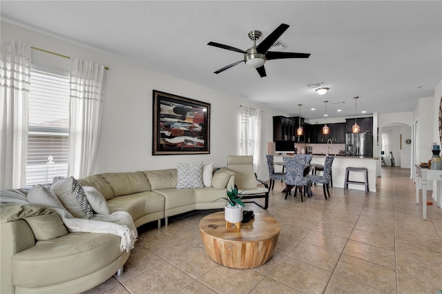 living room with plenty of natural light, ceiling fan, and light tile floors