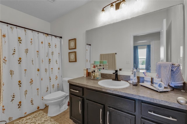 bathroom with tile floors, toilet, and vanity