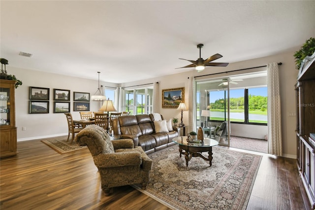 living room with ceiling fan, a healthy amount of sunlight, and dark wood-type flooring