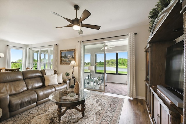 living room with a wealth of natural light and dark wood-type flooring