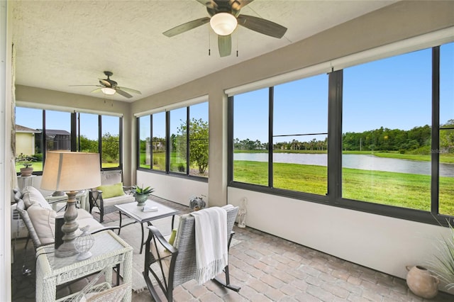 sunroom with a water view and ceiling fan