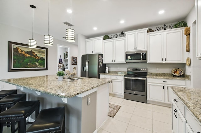 kitchen featuring white cabinets, a kitchen island with sink, and appliances with stainless steel finishes