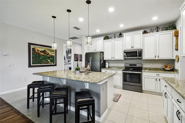 kitchen featuring white cabinets, an island with sink, and stainless steel appliances