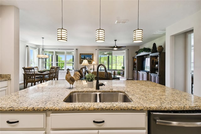 kitchen with white cabinetry, sink, ceiling fan, light stone counters, and decorative light fixtures