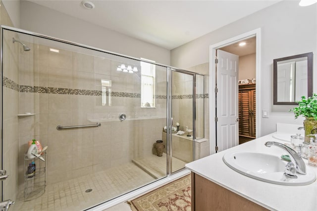 bathroom with vanity and a shower with door