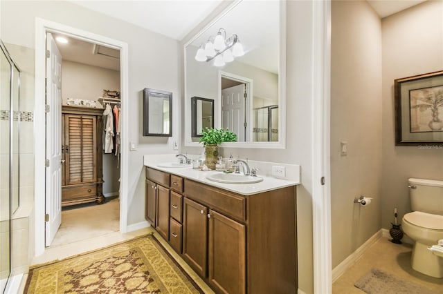 bathroom featuring tile patterned floors, vanity, toilet, and walk in shower