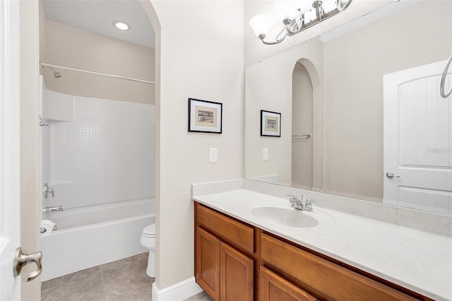 full bathroom featuring tile flooring, bathing tub / shower combination, toilet, and vanity with extensive cabinet space