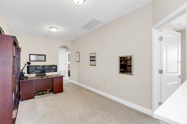 carpeted office space featuring a textured ceiling