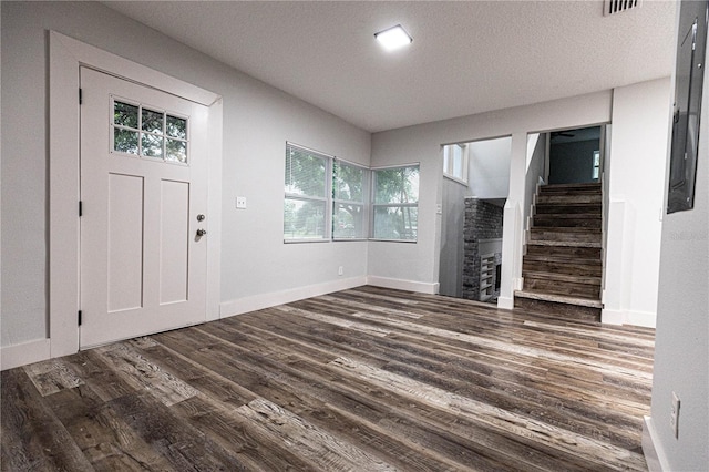 entrance foyer with dark hardwood / wood-style flooring and a textured ceiling