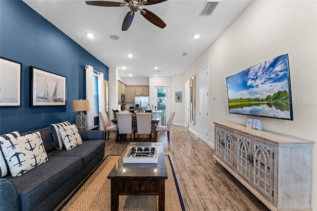 living room with hardwood / wood-style flooring and ceiling fan