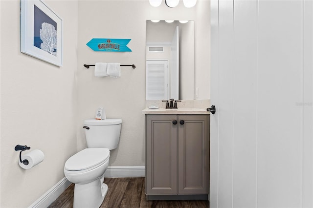 bathroom with toilet, hardwood / wood-style flooring, and vanity