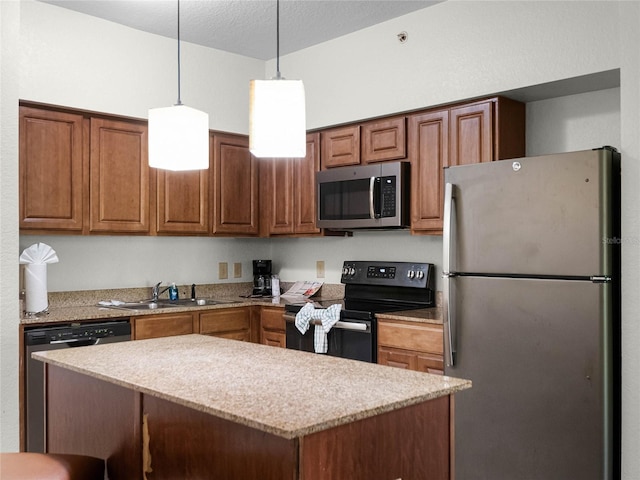 kitchen with decorative light fixtures, stainless steel appliances, a center island, light stone countertops, and sink