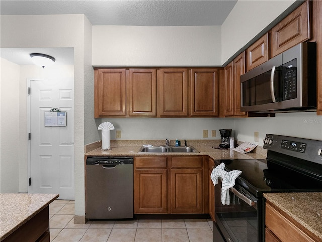 kitchen featuring appliances with stainless steel finishes, sink, and light tile floors