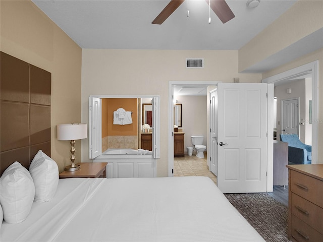 bedroom featuring tile floors, ceiling fan, and ensuite bath