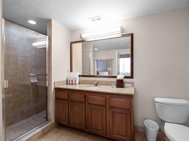 bathroom featuring toilet, tile floors, a shower with shower door, vanity, and a textured ceiling