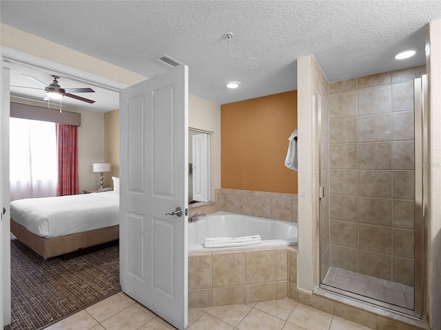 bathroom with tile floors, a textured ceiling, plus walk in shower, and ceiling fan