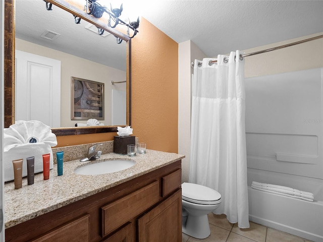 bathroom featuring tile flooring, vanity with extensive cabinet space, a textured ceiling, and toilet