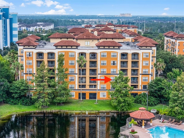 view of property with a community pool and a water view