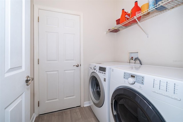 clothes washing area with washing machine and clothes dryer, washer hookup, and hardwood / wood-style floors