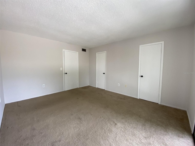 carpeted spare room with a textured ceiling