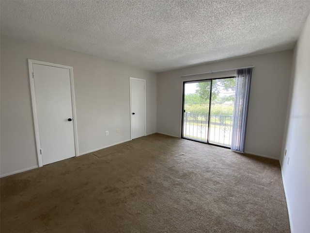 carpeted empty room with a textured ceiling