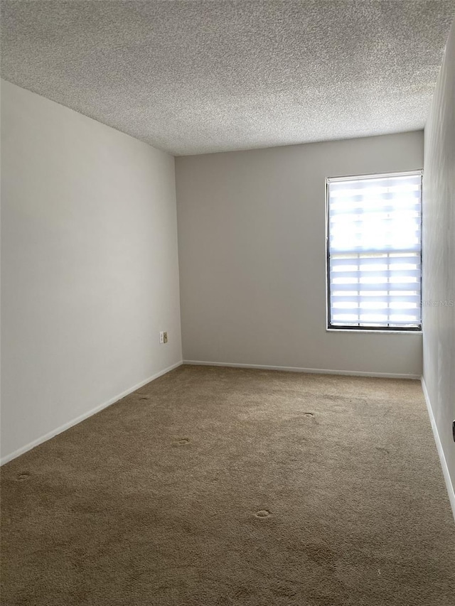 carpeted empty room with a textured ceiling