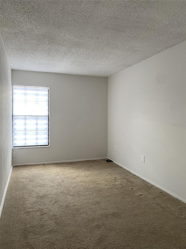 carpeted spare room with a textured ceiling