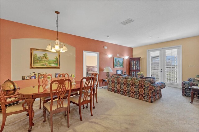 dining room featuring carpet flooring and a notable chandelier